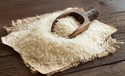 White rice grains in a wooden bowl